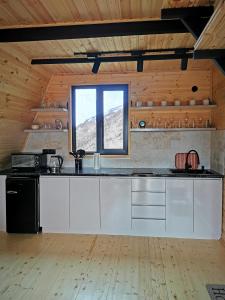 卡兹贝吉Arsha View的厨房配有白色橱柜和窗户。