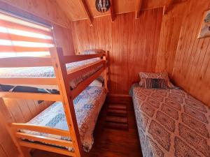 富特罗诺Cabañas Villa Elfo的小屋内的小房间设有两张双层床
