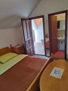 利夫诺Prenoćište San Rooms的一间卧室配有一张床、一张桌子和一面镜子