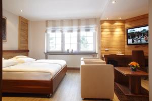 Lipperscheid里维克运动酒店的一间卧室配有两张床、一张桌子和一台电视。
