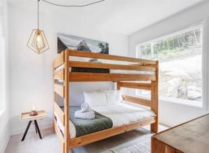 La ConceptionModern Chalet, 10 mins from Tremblant Ski Resort的一间卧室配有一张木制双层床和窗户