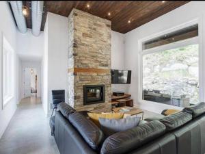 La ConceptionModern Chalet, 10 mins from Tremblant Ski Resort的带沙发和壁炉的客厅