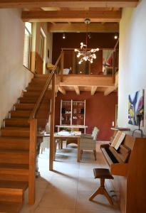 茨维泽尔Chalet Zauberberg的客厅设有楼梯和钢琴