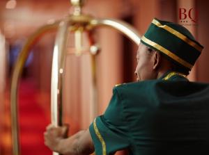 布赖代البندقية للأجنحة الفندقية بريدة BQ hotel suites的穿着绿色制服的人在竖琴上演奏