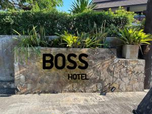 清迈BOSS HOTEL CHIANGMAl的石墙上老板旅馆的一个标志