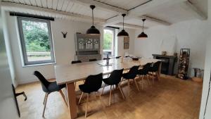 罗谢豪Maison de Rochehaut的用餐室配有大型木桌和椅子