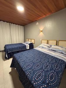 阿廷斯Essência de Atins的一间卧室配有两张带蓝色棉被的床