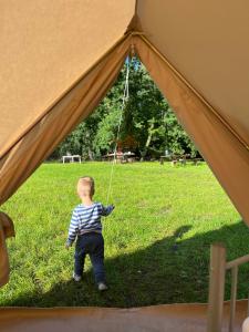 DołgieHelagust的一个小男孩站在帐篷内