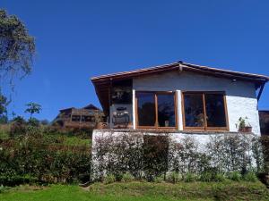 麦德林alto palmas 2.0的坐在田野顶上的一个小房子