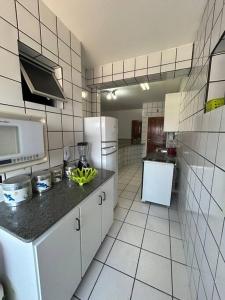 瓜拉派瑞Apartamento de 3 quartos na Praia da Fonte Guarapari的厨房配有白色家电和黑色台面