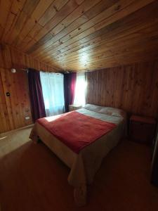 普孔Grandes cabañas的木制客房内的一间卧室,配有一张床