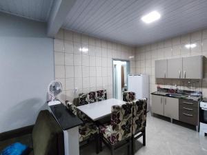 皮拉图巴Casa nas termas de Piratuba的厨房配有桌椅和冰箱。