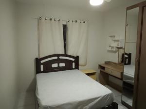 尚格里拉Casa de férias temporada的一间卧室配有一张床、梳妆台和镜子