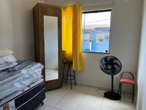 塞古罗港Apartamento mobiliado的一间卧室设有一张床、一个窗口和风扇