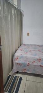 伊达贾伊Descanse e aconchego的一间卧室配有一张带窗帘和地毯的床