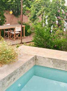 费雷列斯Ses Sucreres Small & Slow Hotel的花园内的游泳池,花园内有桌子和树木