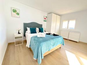 Castillo del RomeralSuites Verano Azul的一间卧室配有一张带蓝色毯子的床