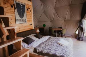 Głęboki BródCzarna Hańcza Glamping的帐篷内一间卧室,配有一张床