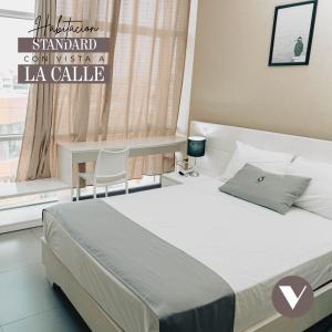 钦博特Hotel Viera Chimbote的一间卧室配有一张床、一张桌子和一个窗户。