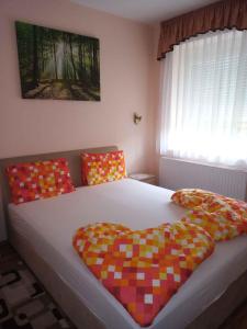 巴拉顿菲兹弗Holiday home Balatonfűzfo/Balaton 18797的一间卧室配有一张带色彩缤纷枕头的大床