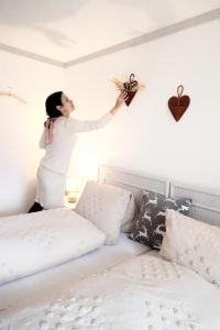 DärligenDoppelzimmer mit Terrasse的站在床上的女人,墙上挂着植物