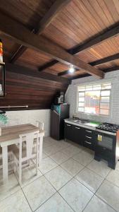 贝卢港Chale Bombinhas/Borto Belo的厨房配有桌子、桌子和炉灶。
