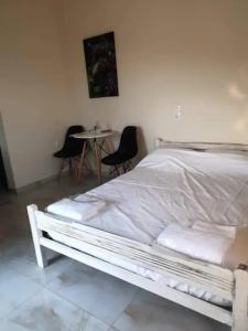 SomatásDamianakis Village Rethymno的一张白色的床,位于带桌椅的房间