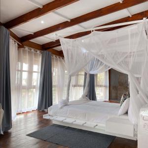 维兰库卢什Samara Lodge的一间卧室配有一张带天蓬的白色床