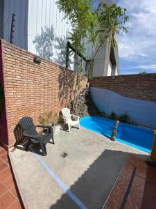 门多萨卢卡波多旅舍的一个带两把椅子的庭院和一个游泳池