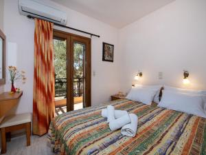 PangalochoriSnug holiday home in Pagkalohori的一间卧室配有一张带白色床单的床和一扇窗户。