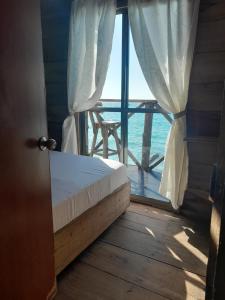 布兰卡滩Mi Cabañita Guest House的一间卧室设有海景窗户