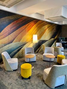 沙托鲁科尔伯特贝斯特韦斯特优质酒店的大堂设有桌椅和色彩缤纷的壁画
