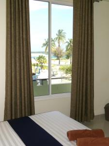 马米基里Oren的一间卧室设有窗户,享有海滩美景