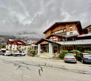 奥雷勒Orelle Val Thorens le hameau des Eaux d'Orelle的停车场内有车辆的建筑物