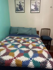 泽西市Genevieve’s comfort pad的卧室里一张床上有五颜六色的被子