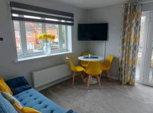 Exhall2 Bedroom Apartment的客厅配有沙发、桌子和黄色椅子