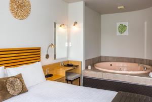 陶波克利尔沃特汽车旅馆的一间卧室配有一张床和浴缸