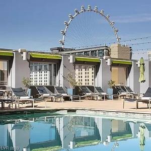 拉斯维加斯Spacious Retro 1 BR Condo with Sphere Views 1 Block from Vegas Strip NO Resort Fees的一座带游泳池和摩天轮的建筑