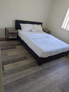 格拉德斯通Christa's 4Bedroom Entire Private House Gladstone City的卧室内的一张床位,铺有木地板