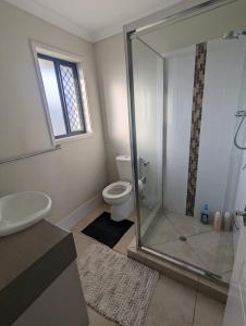 格拉德斯通Christa's 4Bedroom Entire Private House Gladstone City的一间带卫生间和玻璃淋浴间的浴室