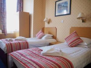 伯恩茅斯Devon Towers Hotel的一间酒店客房,房间内设有两张床