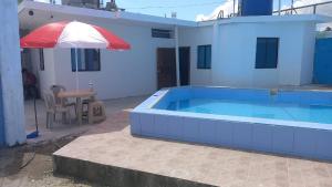 通苏帕Casa Tonsupa的一座房子旁带遮阳伞的游泳池