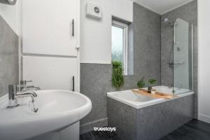 莱姆河下游的纽卡尔斯NEW Poplar House - Stunning 4 Bedroom House in Stoke-on-Trent的浴室设有2个水槽、浴缸和镜子