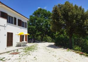 MarmiLa Vecchia Quercia的车道旁的一座房子,上面有一把黄伞
