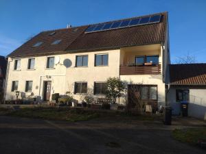 SchrozbergKraewelhof的屋顶上设有太阳能电池板的大型白色房屋