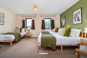 特伦特河畔斯托克NEW Greydawn House - Stunning 4 Bedroom House in Stoke-on-Trent的绿墙客房内的两张床
