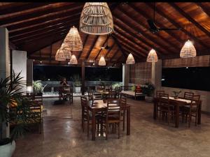 科伦坡萨语拉旅馆的餐厅设有木桌、椅子和吊灯。