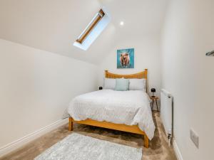 WiggintonSalix 4 - Uk46116的卧室设有白色墙壁和一张带木制床头板的床