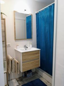 科拉雷侯Apartamento OCEAN PEARL的浴室设有水槽和蓝色的浴帘