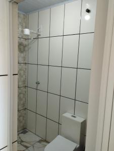 卡舒埃拉保利斯塔Pousada São Benedito的白色的浴室设有卫生间和淋浴。